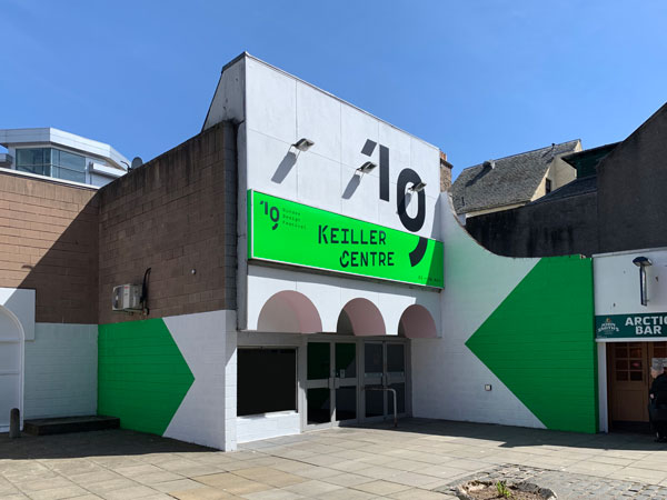 Exterior of the Keiller Centre in the sunshine with freshly painted white exterior, luminous green shapes and black branding for the Dundee Design Festival 2019.