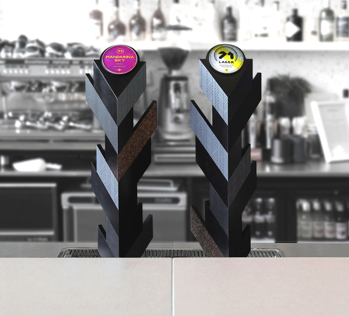 Beer taps installed in the V&A Dundee bar. Two angular taps side by side on a bar top. The different facets of the design use various materials etched with a geometric pattern.