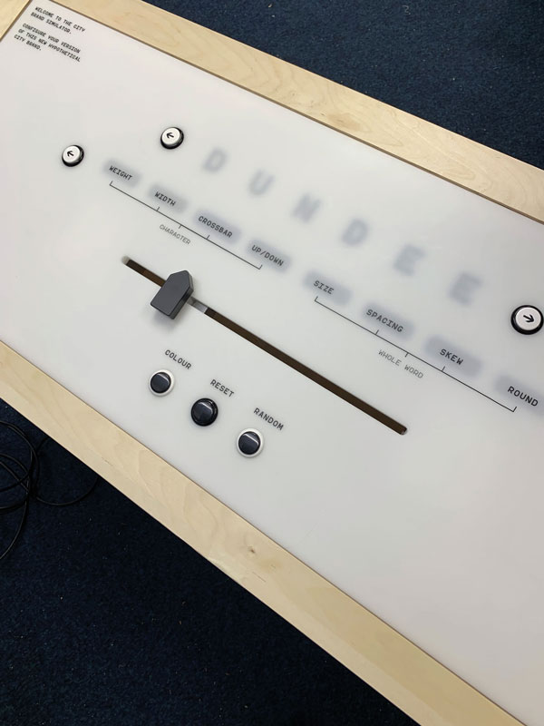 Interactive console with buttons and sliders to allow the manipulation of typography shown on a projector.