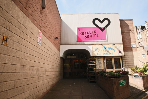 Entrance to the Keiller Centre with luminous pink backing and black branding for the 2019 Dundee Design Festival.