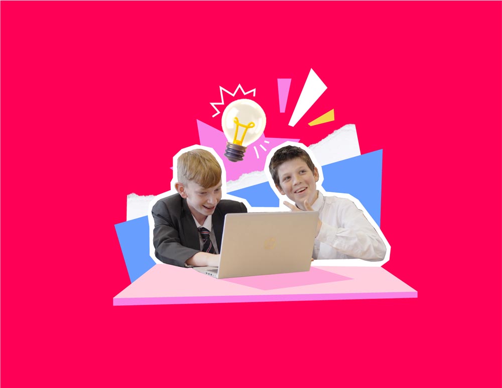 Two students laugh and joke infront of a laptop.